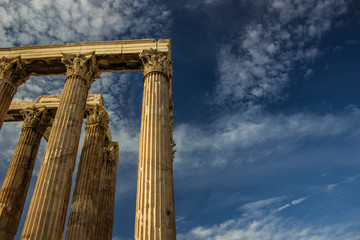 Naklejka premium example of Greek architecture ancient columns ruins of old antique heritage temple shape on vivid blue sky background, empty copy space