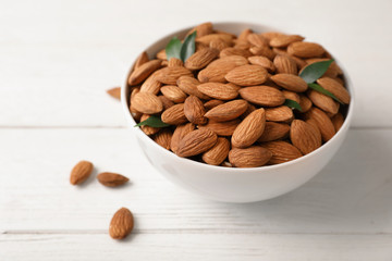 Tasty organic almond nuts in bowl on table