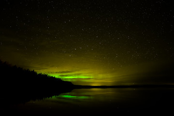 Northern Lights over Lake with clouds and stars