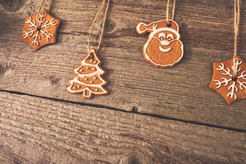 Gingerbread cookies hanging over wooden background. Space for text