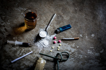Hard drugs and alcohol on dark stone table. Top view