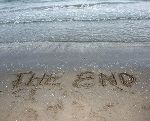 word the end written on the sand