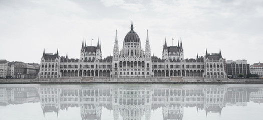 Parliament building in Budapest, Hungary on a cloudy day. Building facade with reflection in water