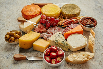 Delicious mix of different snacks and appetizers. Spanish tapas or italian antipasti on a black stone plate. View from above. Placed on stone table.