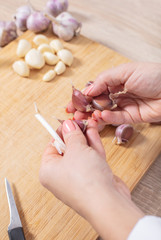 Obraz na płótnie Canvas woman cook cleans garlic cloves