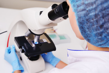 a medic or scientist examines bacteria in a microscope against the backdrop of a bacteriological...