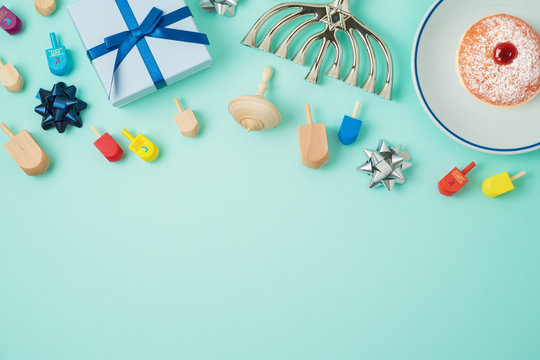 Jewish holiday Hanukkah background with menorah, sufganiyot, gift box and spinning top