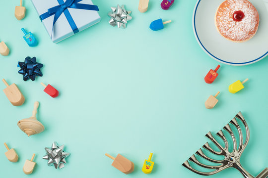 Jewish holiday Hanukkah background with menorah, sufganiyot, gift box and spinning top.