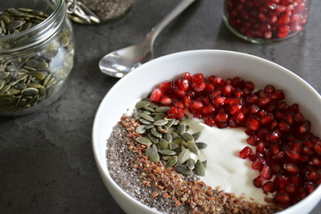 Gesundes Frühstück - Joghurt mit Granatapfelkernen, Kürbiskernen und Chiasamen