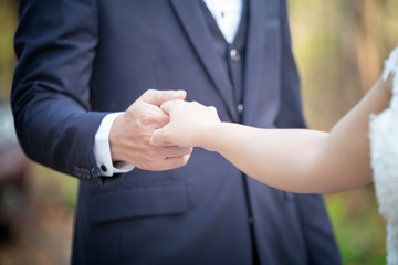 Close up couple holding hands with nature background