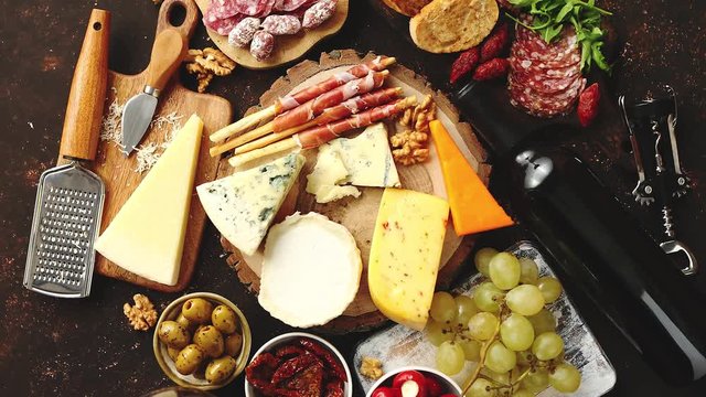 Huge assortment of various tasety spanish, french or italian apertizers. Cheese, meat, olives, stuffed peppers, bread, sticks. Placed on rusty dark background. View from above.