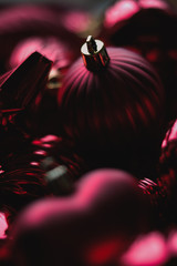 Close up of dark red christmas decoration ornaments, balls, baubles, stars, swirls and heart shaped with golden details and bokeh blur in background for festive holiday or seasons greetings card © Corinna Haselmayer