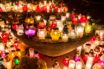 Candles burning at cemetery during All Saints' Day at night.