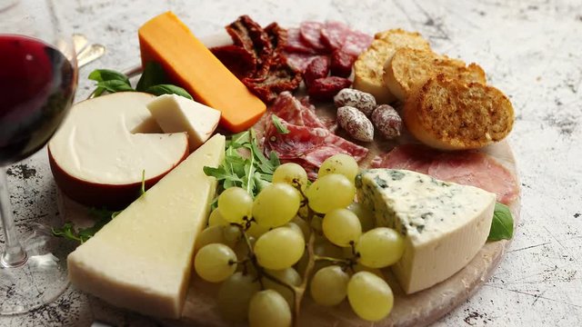 Assortment of spanish tapas or italian antipasti with meat, ham, olives, cheese, nuts and bread placed on a white rusty table. Top view flat lay with copy space background