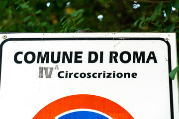 Text "Comune di Roma IV circoscrizione" (Italian for "Urban district of Rome, IV municipality") written on a street signal