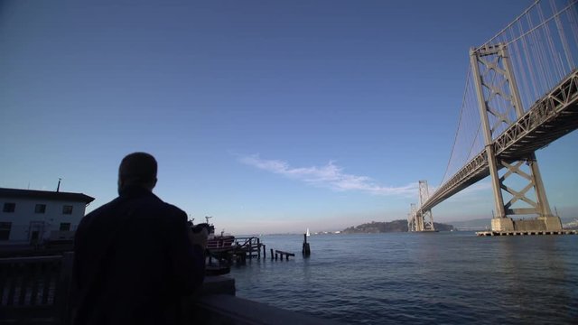 A photographer takes pictures of the Bay Bridge, San Francisco Bay