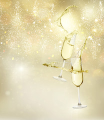 Two festive champagne glasses levitating on golden bokeh background with lights © neirfy
