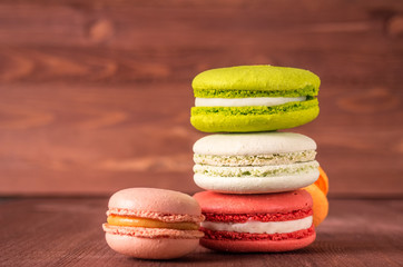 Colorful French or Italian macarons stack on wooden background put with copy space for background