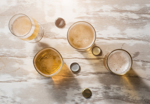 Glasses of beer with reflection on table wooden