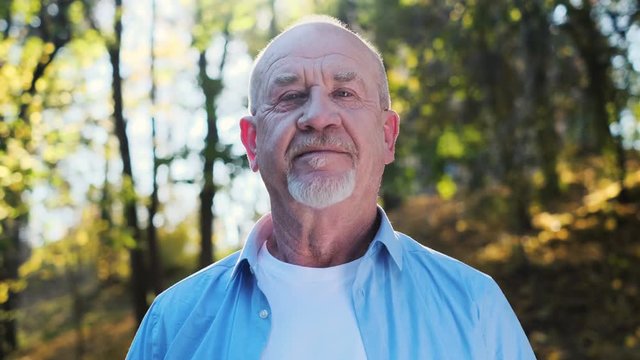 Portrait of stressful sad senior elderly caucasian old man with a beard in the park outdoors. Spring healthcare lifestyle eldery stress painful retirement golden age crisis