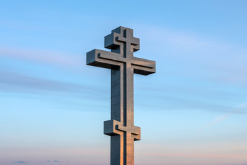 stone christian cross on blue sky