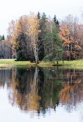 Fototapeta na wymiar Calm water in the river and autumn trees on the shore.