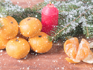 Fototapeta na wymiar Christmas mandarines on wooden background, lighted candle