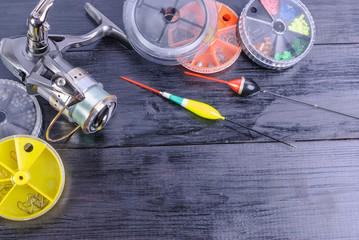 Fishing tackle - reel, floats, fishing line on a wooden background