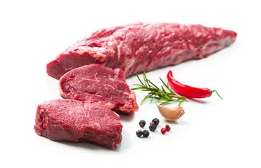 Fototapeten Whole piece of tenderloin with steaks and spices ready to cook isolated on white background © Alexander Raths