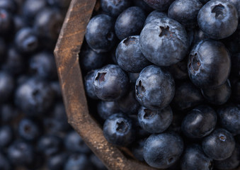 Fresh raw organic blueberries in vintage wooden box on stone kitchen background. Top view. Macro