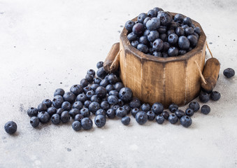 Fresh raw organic blueberries in vintage wooden box on stone kitchen background. Food concept