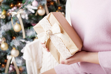 Fototapeta na wymiar Сhild's hands holding gift box. Christmas, hew year, birthday concept. Festive background with bokeh and sunlight. Magic fairy tale