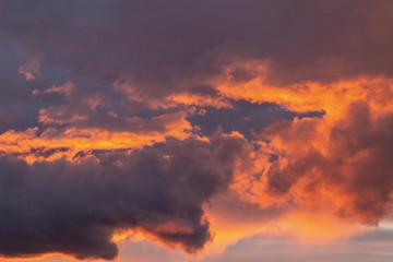 Dramatic sunset sky with orange colored clouds.