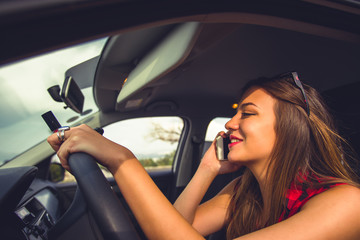 Fototapeta na wymiar Businesswoman talking on the phone in the car and driving recklessly