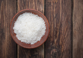 Sea salt in wooden bowl on the wooden table,top view