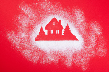 Christmas House stencil of powdered sugar on a red background.