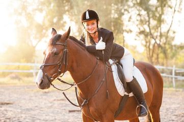 Girl equestrian rider riding a beautiful horse  in the rays of the setting sun. Horse theme