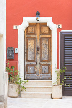 Presicce, Apulia - An old wooden door and a bordeaux facade