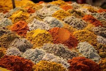 Piles of colourful mixed spices presented in layers at the bazaar of Isfahan, Iran.