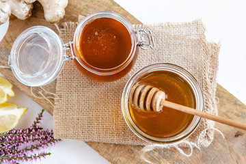 Honey in jar with fresh heather on wooden background