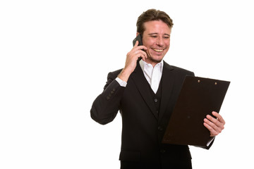 Happy Caucasian businessman talking on mobile phone while readin