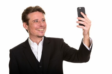 Happy Caucasian businessman taking selfie with mobile phone