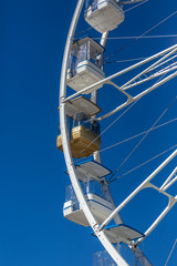 Giant ferris wheel with chairs, metallic structure, recreational element near the river