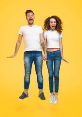 Jumping bright couple on yellow background