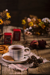 English Tea Time. Cup of tea with cookies on wooden table, rustic homemade interior.