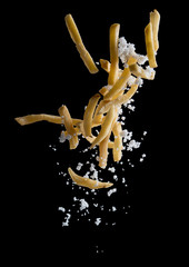 French fries with salt explode flying in the air isolated on black background,Stop motion