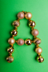 Letter A made of Christmas toys on green background. ABC