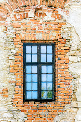 The wooden window of the old house, the stone wall without plaster_