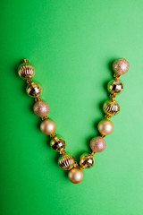 Letter V made of Christmas toys on green background. ABC