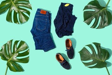 Flat lay set autumn male clothes jeans pullover shoes turquoise background top view